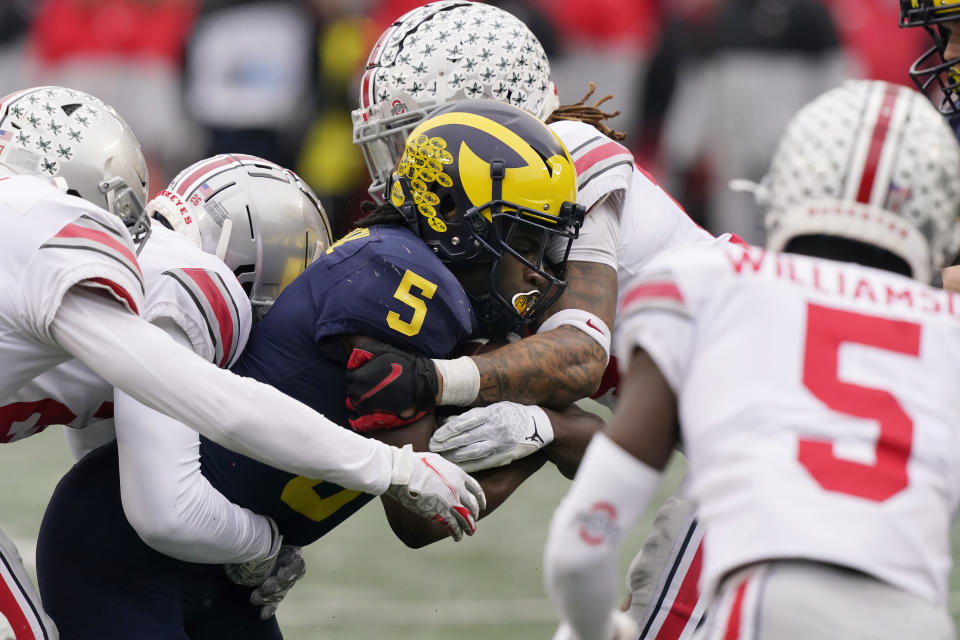 Michigan wide receiver Mike Sainristil (5) is stopped by the Ohio State defense during the second half of an NCAA college football game, Saturday, Nov. 27, 2021, in Ann Arbor, Mich. (AP Photo/Carlos Osorio)