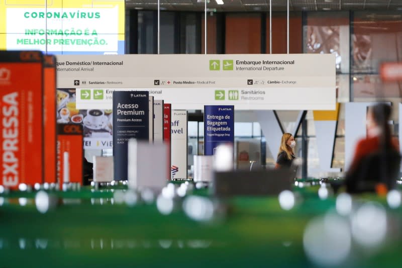 A traveler wearing a protective face mask walks at Brazilian International Airport amid the coronavirus disease (COVID-19) outbreak in Brasilia