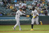 Chicago White Sox's Yoán Moncada (10) celebrates with third base coach Joe McEwing (99) after hitting a three-run home run against the Oakland Athletics during the second inning of a baseball game in Oakland, Calif., Thursday, Sept. 8, 2022. (AP Photo/Godofredo A. Vásquez)