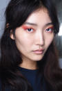 <p>Bold orange eyeshadow accentuates this model’s brunette locks. (Photo: NARS) </p>