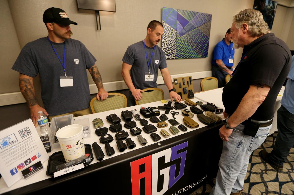 Adam Van Bruaene, center, owner of Adam's Gear Solutions, offers holsters as one of the vendors May 8-11 at the national conference of the Midwest Gang Investigators Association at the Doubletree Hotel in South Bend.