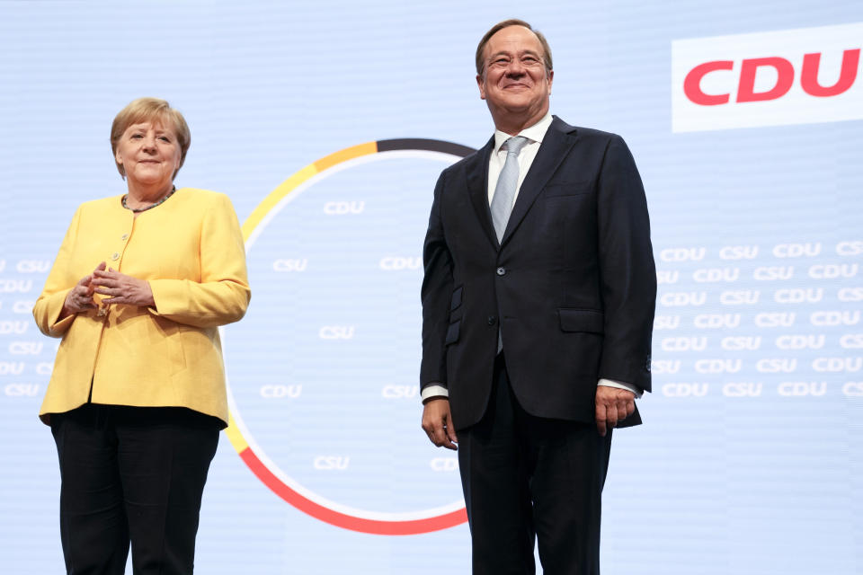FILE - In this Saturday, Aug. 21, 2021 file photo Armin Laschet, right, the center-right Union bloc's candidate for chancellor in Germany's September election, and outgoing Chancellor Angela Merkel attend an event in Berlin kicking off the conservatives' official election campaign in Germany. A large chunk of the German electorate remains undecided going into an election that will determine who succeeds Angela Merkel as chancellor after 16 years in power. Recent surveys show that support for German political parties has flattened out, with none forecast to receive more than a quarter of the vote. (Photo/Markus Schreiber, file)