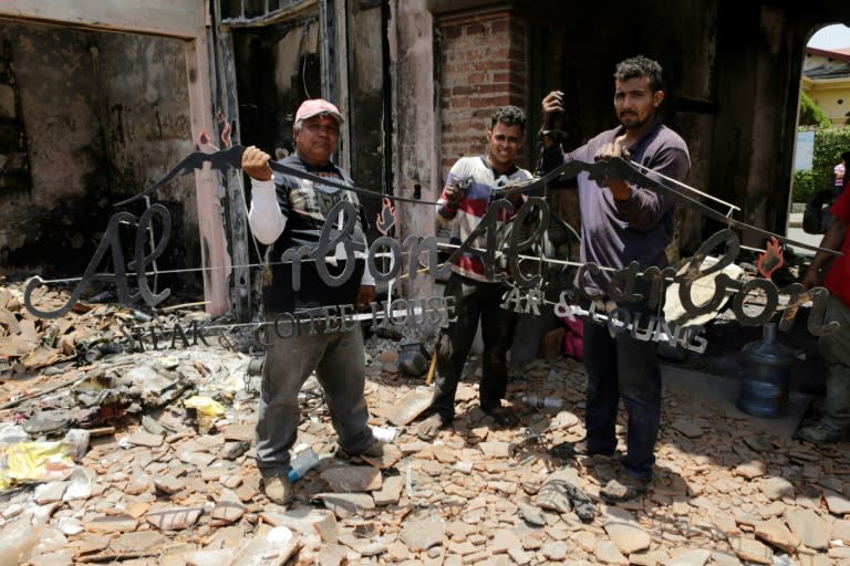 Workers clear the rubble of a restaurant in the Nicaraguan city of Leon, after it was set on fire during protests against President Daniel Ortega's government