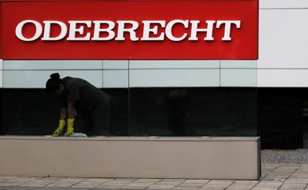 FILE PHOTO: A worker cleans the corporate logo of the Odebrecht SA construction conglomerate at its headquarters in Sao Paulo