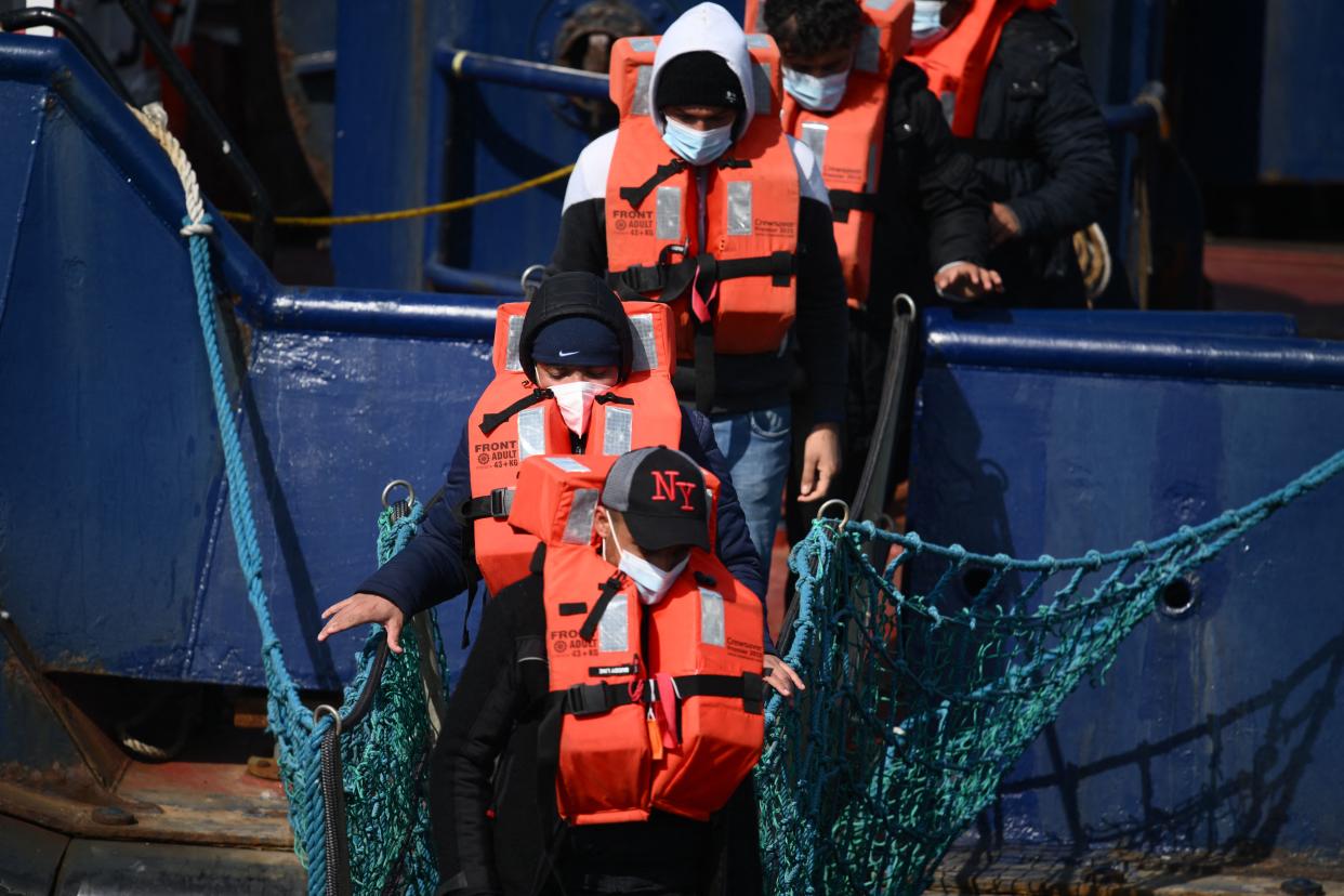 A group of migrants disembark from a UK Border Force boat at the port of Dover having being picked up crossing the English Channel from France on April 15, 2022, at Dover, on the south-east coast of England. - Britain will send migrants and asylum seekers who cross the Channel thousands of miles away to Rwanda under a controversial deal announced Thursday as the government tries to clamp down on record numbers of people making the perilous journey. (Photo by Daniel LEAL / AFP) (Photo by DANIEL LEAL/AFP via Getty Images)