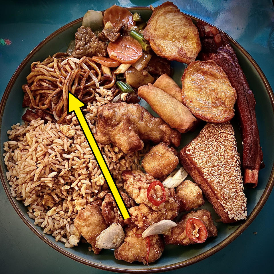 plate of various chinese takeout items, including chow mein in the corner