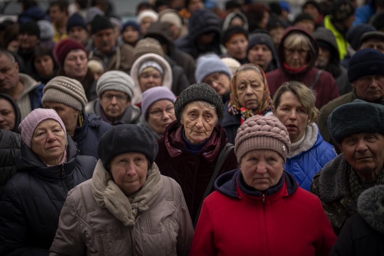 FILE - Ukrainians wait for a food distribution organized by the Red Cross in Bucha, on the outskirts of Kyiv, on April 18, 2022. 