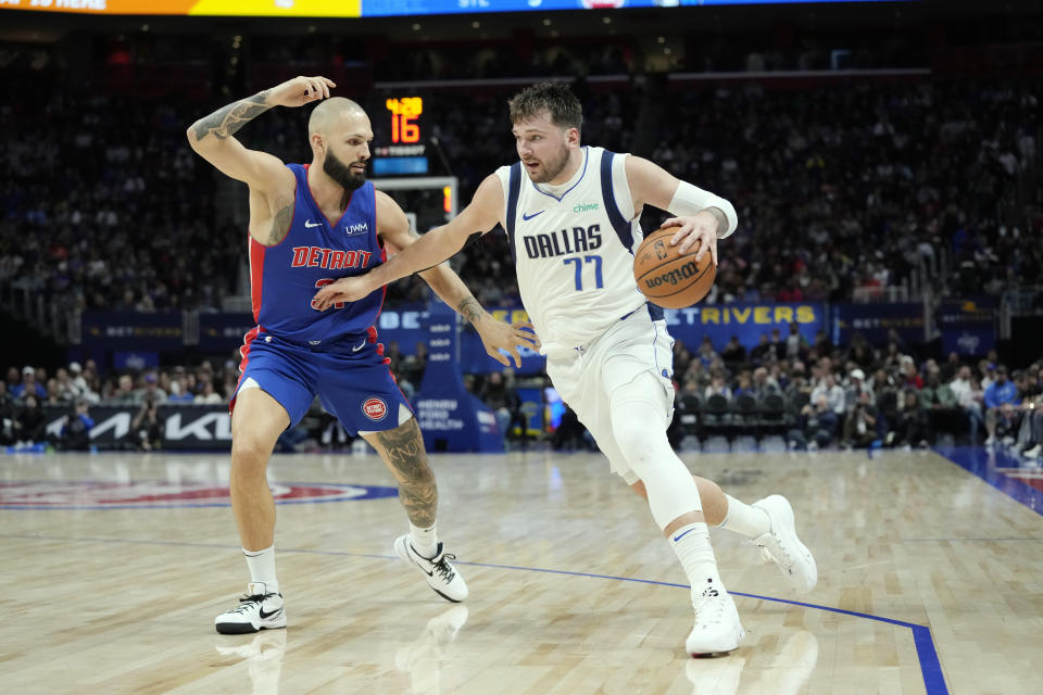 Dallas Mavericks guard Luka Doncic (77) is defended by Detroit Pistons guard Evan Fournier during the second half of an NBA basketball game, Saturday, March 9, 2024, in Detroit. (AP Photo/Carlos Osorio)