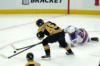 Boston Bruins defenseman Matt Grzelcyk (48) and New York Rangers defenseman Anthony Bitetto (22) chase the puck in the first period of an NHL hockey game, Thursday, May 6, 2021, in Boston. (AP Photo/Elise Amendola)