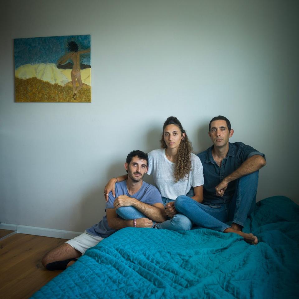 Liri, Roni and Gili Roman in their father's apartment in Tel Aviv, where Yarden, with her husband and daughter, were planning to live, on Oct. 16. One of Yarden's paintings hangs on the wall. <span class="copyright">Michal Chelbin for TIME</span>