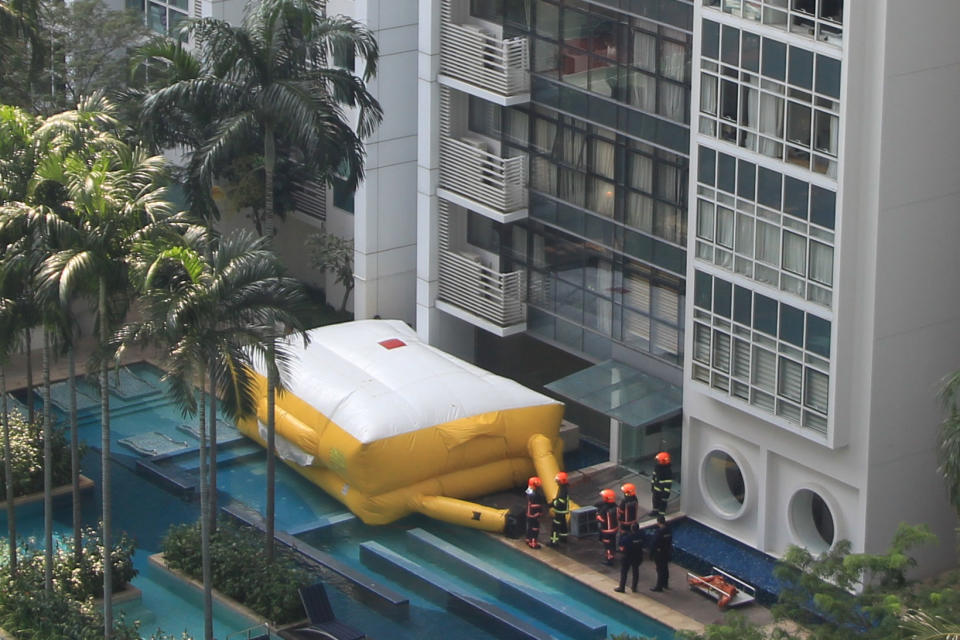 SCDF officers seen next to a safety life air pack set up below the condominium block. (PHOTO: Dhany Osman / Yahoo News Singapore)