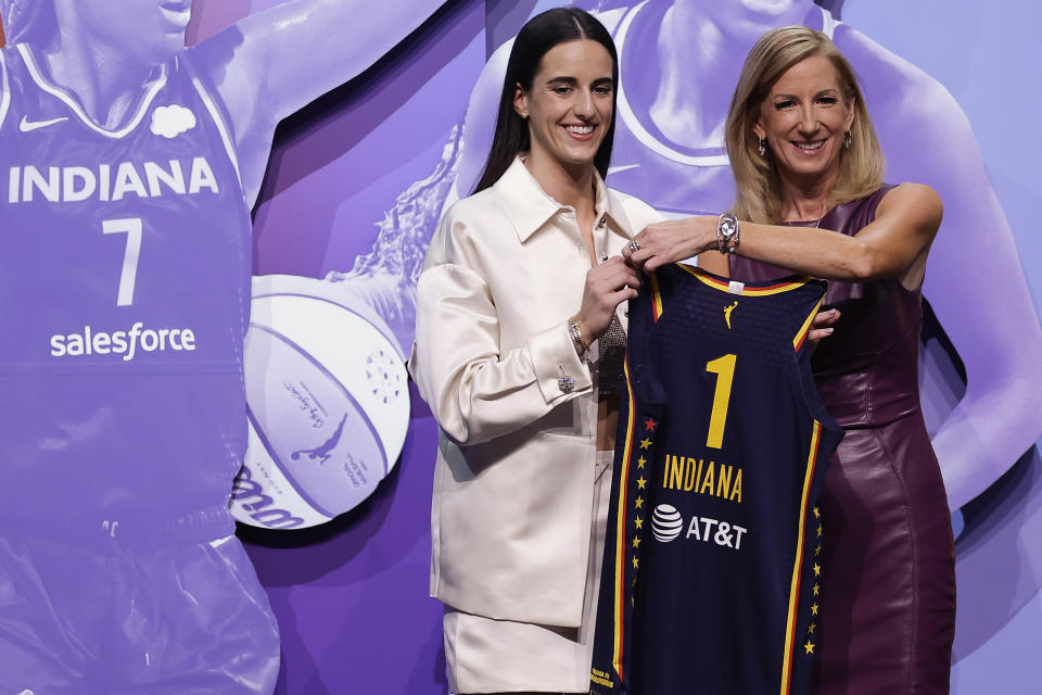 CORRECTS TO CAITLIN CLARK NOT CAITLYN CLARK - Iowa's Caitlin Clark, left, poses for a photo with WNBA commissioner Cathy Engelbert, right, after being selected first overall by the Indiana Fever during the first round of the WNBA basketball draft, Monday, April 15, 2024, in New York. (AP Photo/Adam Hunger)