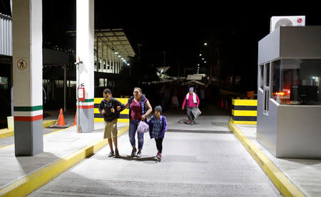 People belonging to a caravan of migrants from Honduras en route to the United States, walk at the border crossing to Mexico, in Hidalgo, Mexico, January 18, 2019. REUTERS/Jose Cabezas