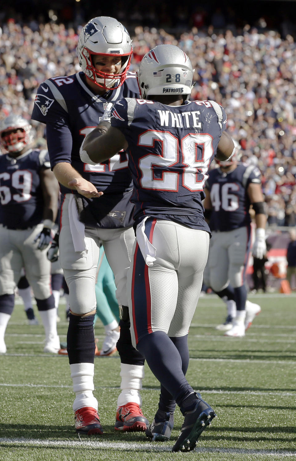 New England Patriots running back James White, right, celebrates his touchdown catch with quarterback Tom Brady during the second half of an NFL football game against the Miami Dolphins, Sunday, Sept. 30, 2018, in Foxborough, Mass. (AP Photo/Steven Senne)