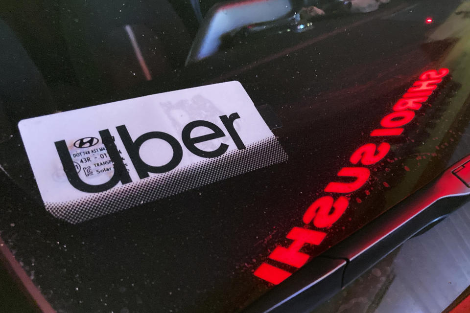 FILE - An Uber sign is displayed inside a car in Glenview, Ill., Saturday, Dec. 17, 2022. Consumers will pay more for that airline flight or willing to fork out more for a ride on Uber during rush hour. But a big shopper backlash to media reports this past week that fast-food chain Wendy’s had plans to increase prices during the busiest time at its restaurants clearly showed that consumers don’t want basic food items like hamburgers and shakes going up and down(AP Photo/Nam Y. Huh, File)