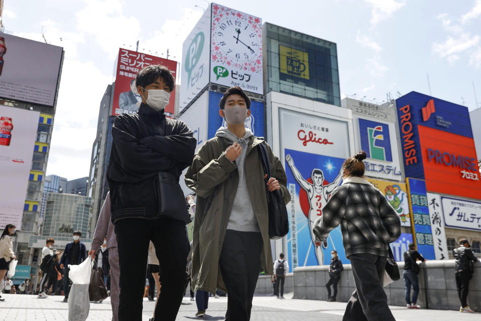 People wearing face masks to help curb the spread of the coronavirus in Osaka, western Japan, Monday, April 5, 2021. Osaka prefecture issued a special warning Wednesday, April 7, 2021 over the rapid upsurge of the coronavirus cases that has put the area's medical systems on the brink of collapse, requesting the cancellation of the Olympic torch relay on public roads. (Juntaro Yokoyama/Kyodo News via AP)