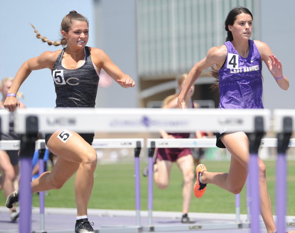 Clyde's Payton Phillips (left) runs next to Merkel's Alyssa O'Malley in the 100 hurdles at the Region I-3A track and field meet at Abilene Christian University on April 30.