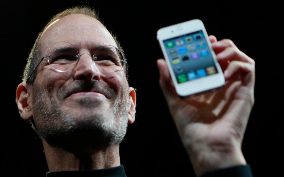 Steve Jobs posing with a fourth generation iPhone in 2010, a year before he died - Credit: AP