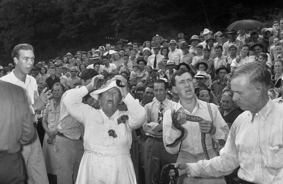 FILE - In this Aug. 6, 1944 file photo, members of the Holiness Faith Healers sect handle poisonous snakes in Stone Creek, Va. as a memorial to Rev. Johnnie Hensley who died after being bitten on July 28, 1944 by a snake being held by Rev. Oscar Hutton, right, a sect member for 23 years. (AP Photo)