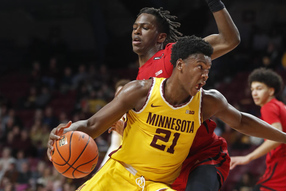 Minnesota forward Pharrel Payne (21) moves around Rutgers forward Antwone Woolfolk during the first half of an NCAA college basketball game Thursday, March 2, 2023, in Minneapolis. (AP Photo/Bruce Kluckhohn)