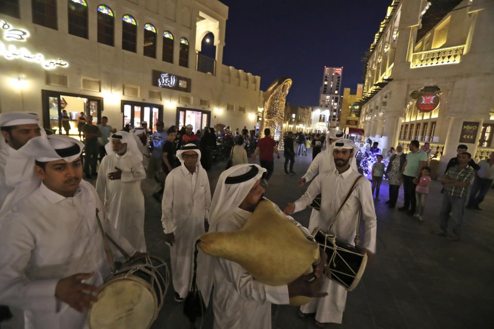 FILE - Qatari musicians perform traditional songs at Souq Waqif in Doha, Qatar, Thursday, April 25, 2019. As many as 1.7 million people could pour into Qatar during the upcoming 2022 FIFA World Cup that begins this November representing over half the population of this small, energy-rich Arab nation. (AP Photo/Kamran Jebreili, File)