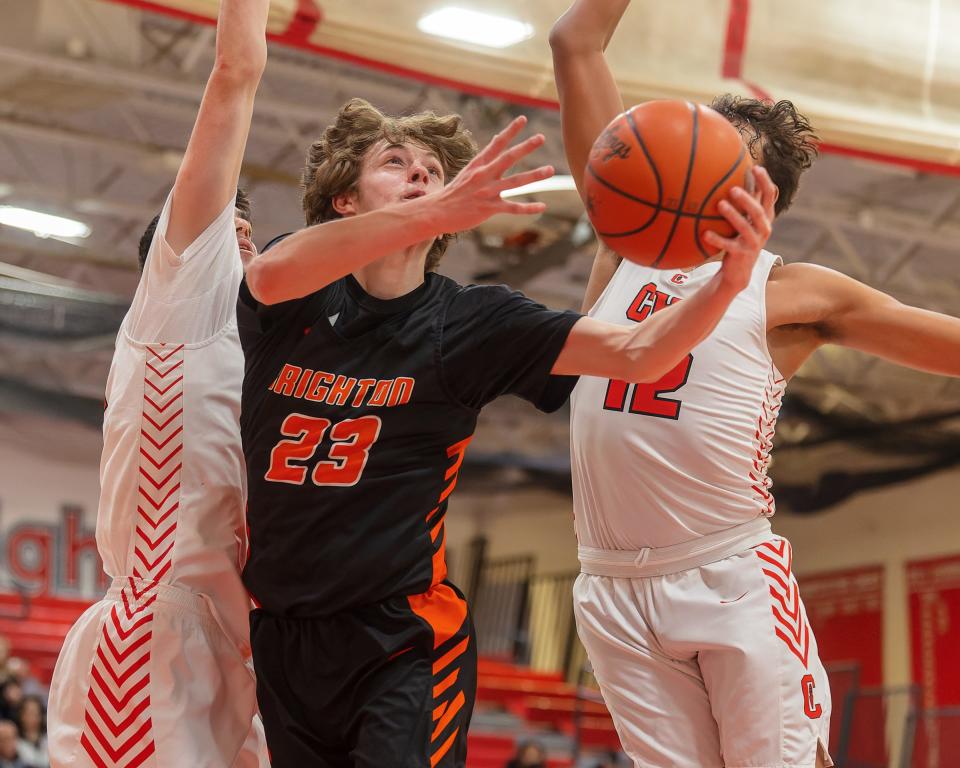 Brighton's Eddie Millington (23) tries to split Canton defenders Omar Suleiman (left) and Dante Favor during the Bulldogs' 67-45 loss on Friday, Feb. 17, 2023.