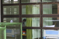 A patient sits inside a quarantine facility for people showing symptoms of the COVID-19 amid the coronavirus outbreak at Patriot Candrabhaga stadium in Bekasi on the outskirts of Jakarta, Indonesia, Tuesday, Sept. 22, 2020. (AP Photo/Achmad Ibrahim)