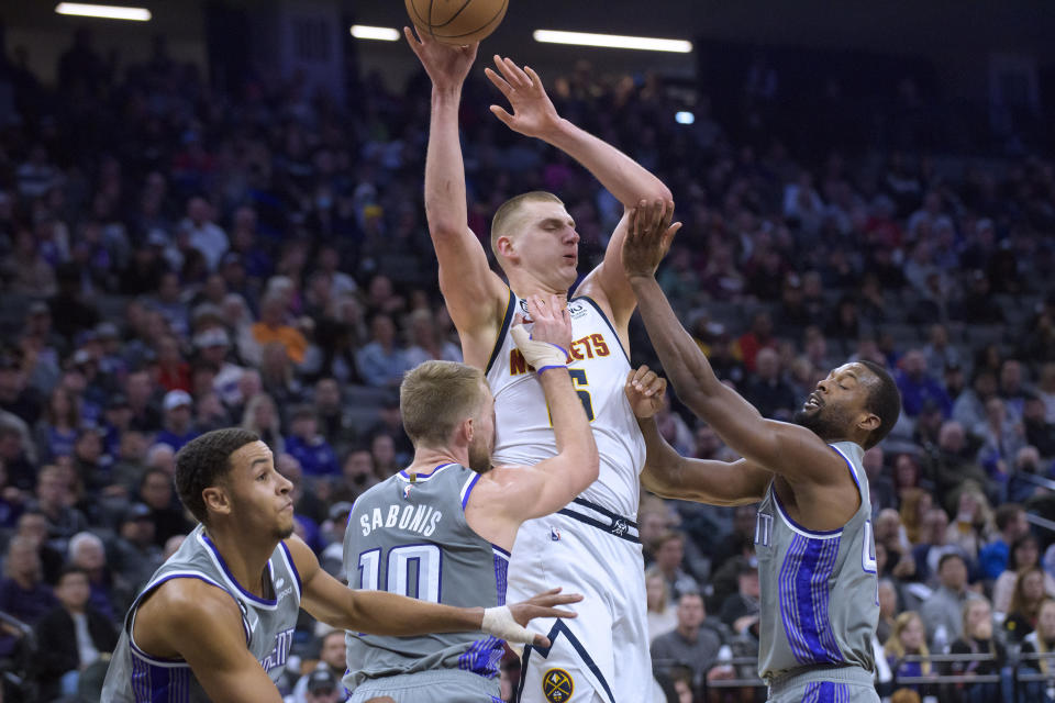 Denver Nuggets center Nikola Jokic is guarded by Sacramento Kings forward Domantas Sabonis and Harrison Barnes during the first quarter of an NBA basketball game in Sacramento, Calif., Wednesday, Dec. 28, 2022. (AP Photo/Randall Benton)