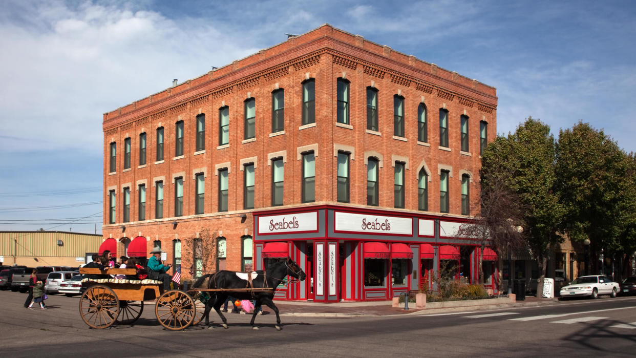 Pueblo, Colorado, USA - October 29, 2011: An old fashioned horse drawn carriage filled with kids and driven by a cowboy rolls onto North Union Ave.