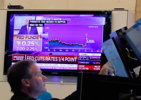 A trader looks on as a screen displays the U.S. Federal Reserve interest rates announcement on the floor of the New York Stock Exchange (NYSE) in New York