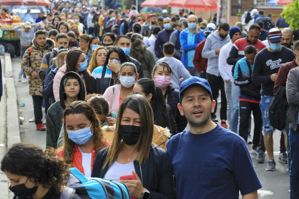 Voters line up at a polling station during a runoff presidential election in Bogota, Colombia, Sunday, June 19, 2022. (AP Photo/Jaime Saldarriaga)