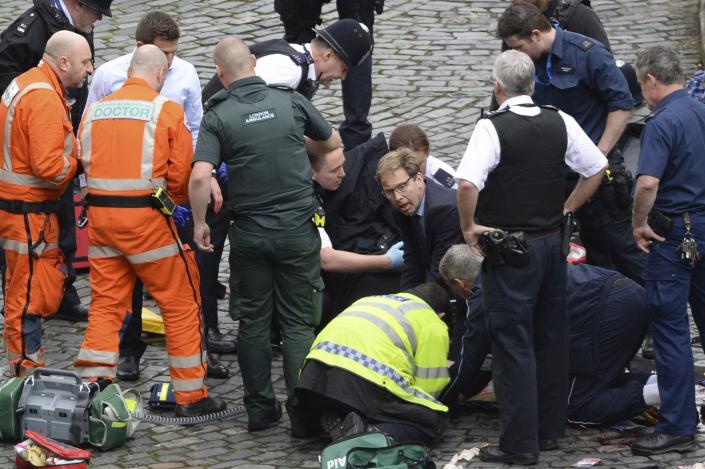 <p>Conservative Member of Parliament Tobias Ellwood, centre, helps emergency services attend to an injured person outside the Houses of Parliament, London, Wednesday, March 22, 2017. London police say they are treating a gun and knife incident at Britain’s Parliament “as a terrorist incident until we know otherwise.” The Metropolitan Police says in a statement that the incident is ongoing. It is urging people to stay away from the area. Officials say a man with a knife attacked a police officer at Parliament and was shot by officers. Nearby, witnesses say a vehicle struck several people on the Westminster Bridge. (Stefan Rousseau/PA via AP). </p>