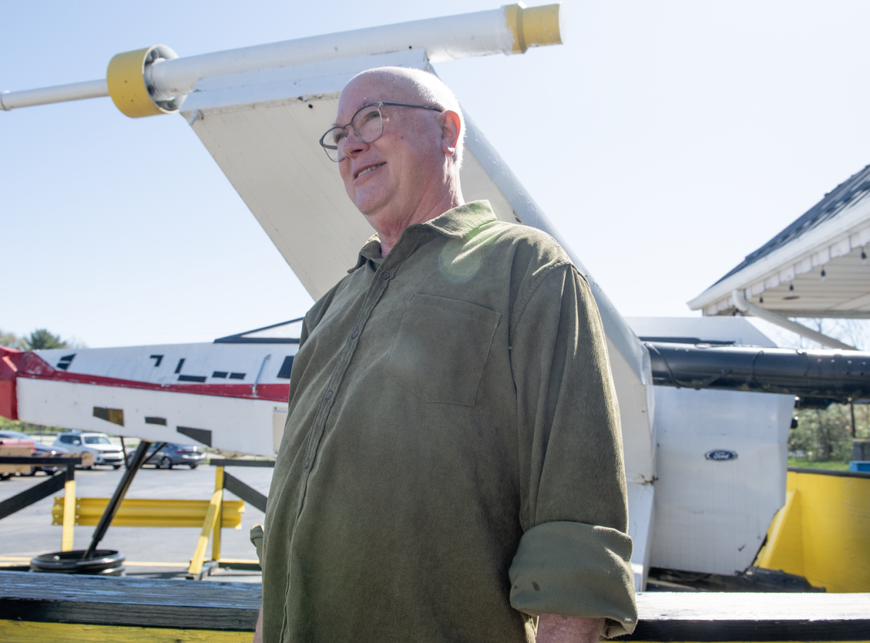 Mike's Place owner, Mike Kostensky, stands beside the X-wing starfighter displayed in front of the Kent restaurant.