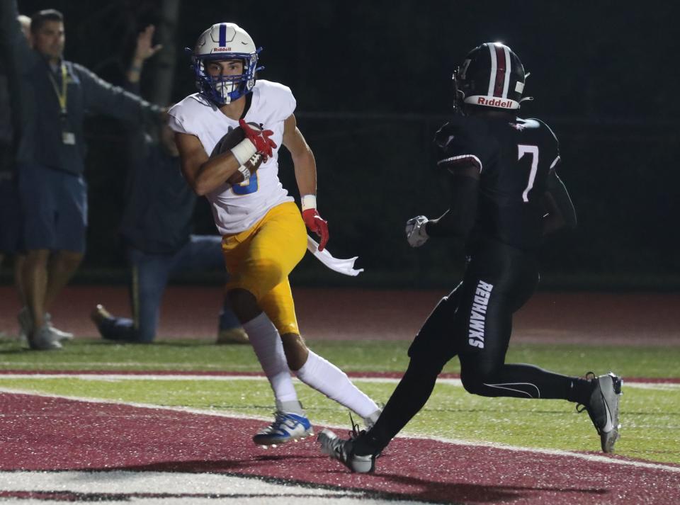 Ardsley's Anthony Chenard runs in a pass for a touchdown in front of Nyack's Abdul Durosinmi during their game at Nyack Sept. 8, 2023. Ardsley won 23-20.