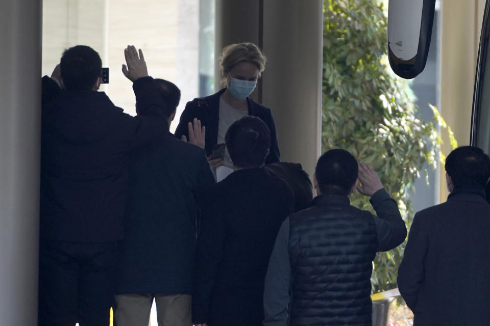 Workers wave farewell as a member of a World Health Organization team of experts prepares to leave from a quarantine hotel in Wuhan in central China's Hubei province Thursday, Jan. 28, 2021. The WHO team emerged from quarantine to start field work in a fact-finding mission on the origins of the virus that caused the COVID-19 pandemic. (AP Photo/Ng Han Guan)