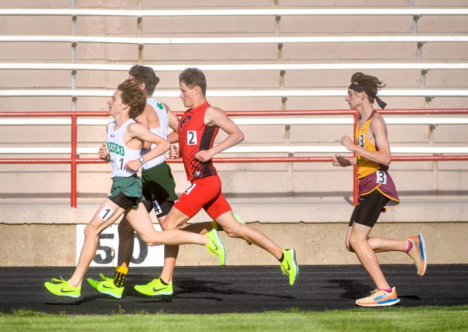 Pekin's Devon Hayes (2) battles Geneseo's Dylan Gehl (1), Jaxson Sottos and East Peoria's Ayden Thompson in the 3200-meter run Friday, April 28, 2023 during the Pekin Dragons Invitational at Pekin Memorial Stadium. Gehl finished first, Hayes second, Thompson third and Sottos fourth.