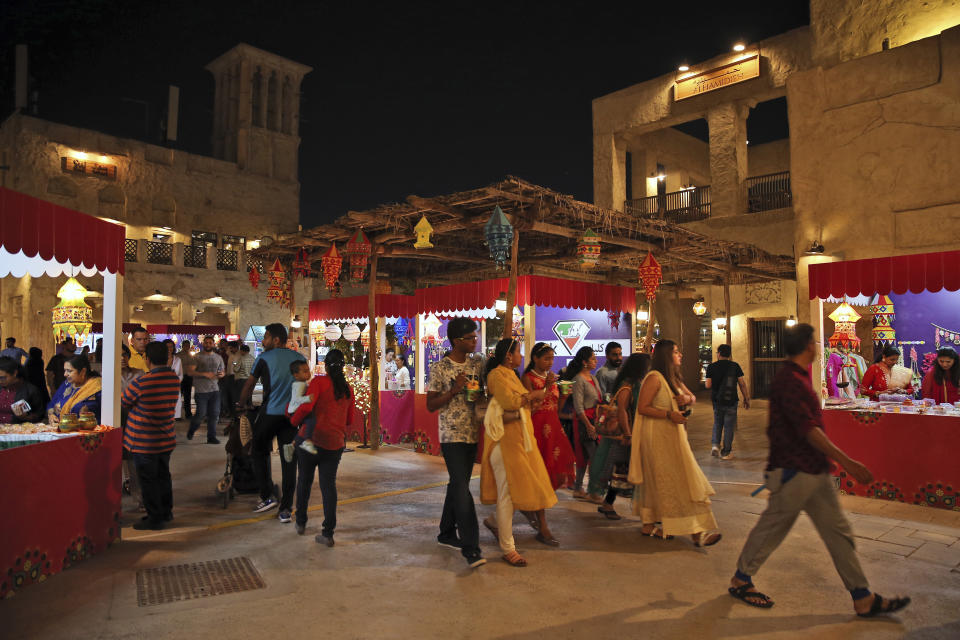 FILE - In this Nov. 7, 2018 file photo, Indians walk in the Al Seef district during the Diwali festival in Dubai, United Arab Emirates. Amid the Kashmir crisis, Gulf Arab states balance relations with Muslim-majority Pakistan, trade partner India. In the UAE Indians outnumber Emiratis three to one and bilateral trade surpassed $50 billion in 2018, making India the UAE’s second-largest trade partner. (AP Photo/Kamran Jebreili, File)