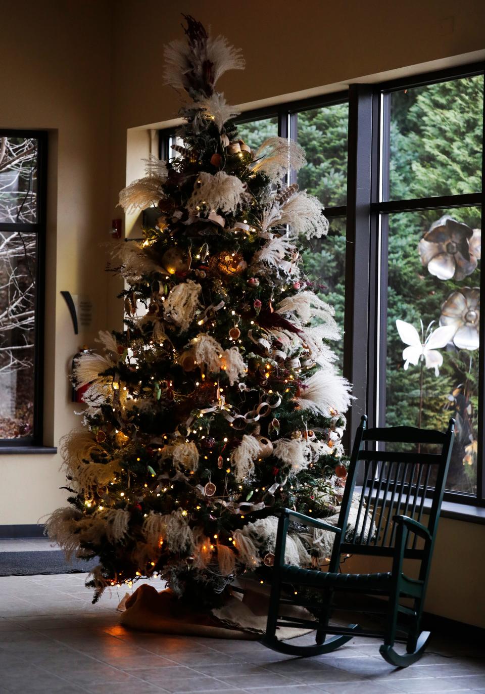 The backdrop for visits by Mrs. Claus at WPS Garden of Lights is a whimsical tree decorated with grasses, dried flowers, garlands strung with beans and birch bark and assorted birds.