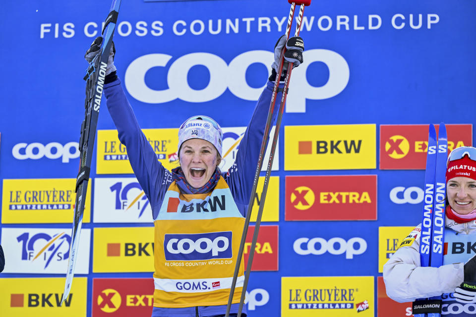 Winner Jessie Diggins of the United States, celebrates on the podium after the women's mass start 20km free race, of the FIS Cross-Country World Cup at the Nordic Center Goms, in Geschinen, Switzerland, Sunday, Jan. 28, 2024. (Jean-Christophe Bott/Keystone via AP)