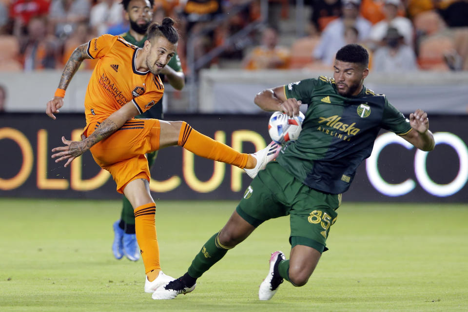 Houston Dynamo forward Maximiliano Urruti, left, kicks the ball into Portland Timbers defender Zac McGraw (85) during the second half of an MLS soccer match Wednesday, June 23, 2021, in Houston. (AP Photo/Michael Wyke)