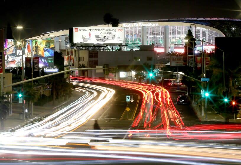 INGLEWOOD, CALIF. - FEB. 2, 2022. Traffic streams down Manchester Boulevard towards SoFi Stadium, background, site of Super Bowl LVI on Sunday, Feb. 13, 2022. (Luis Sinco / Los Angeles Times)