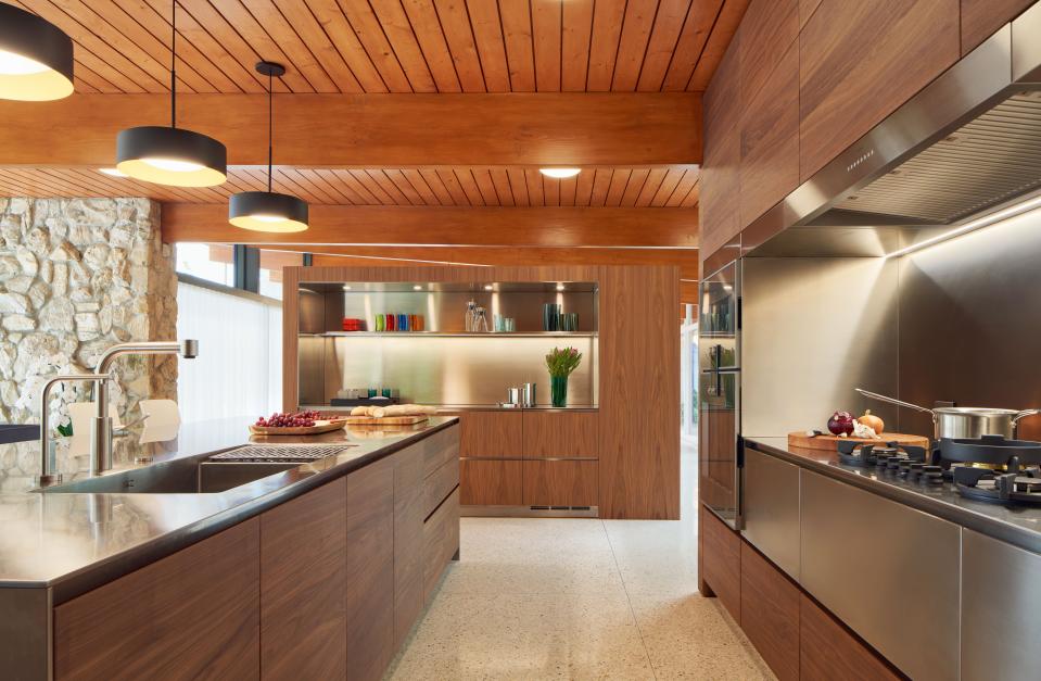 Lynch put in Poliform cabinets, and separated the kitchen from the dining room with a custom-designed walnut built-in, made in Chicago and shipped to Malibu for installation. They hid appliances cleverly in built-ins lined with stainless steel.