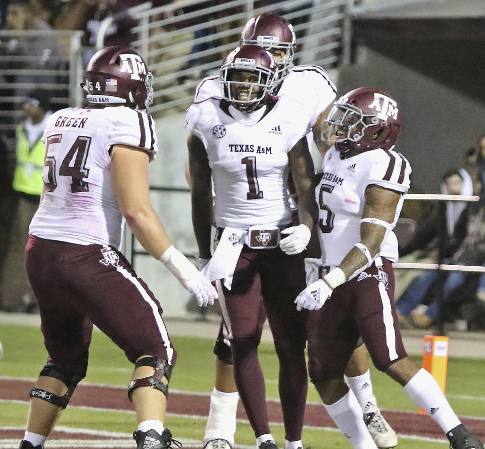 Texas A&M wide receiver Quartney Davis (1) celebrates after scoring a touchdown with teammates Carson Green (54), and Trayveon Williams (5) during the first half of their college football game against Mississippi State Saturday, Oct. 27, 2018, in Starkville, Miss. (AP Photo/Jim Lytle)