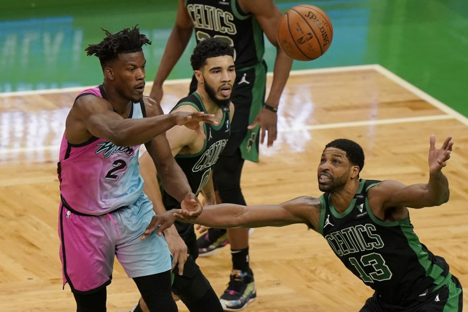 Miami Heat's Gabe Vincent, left, passes the ball as Boston Celtics' Jayson Tatum, center, and Tristan Thompson, right, try to block in the first half of a basketball game, Sunday, May 9, 2021, in Boston. (AP Photo/Steven Senne)