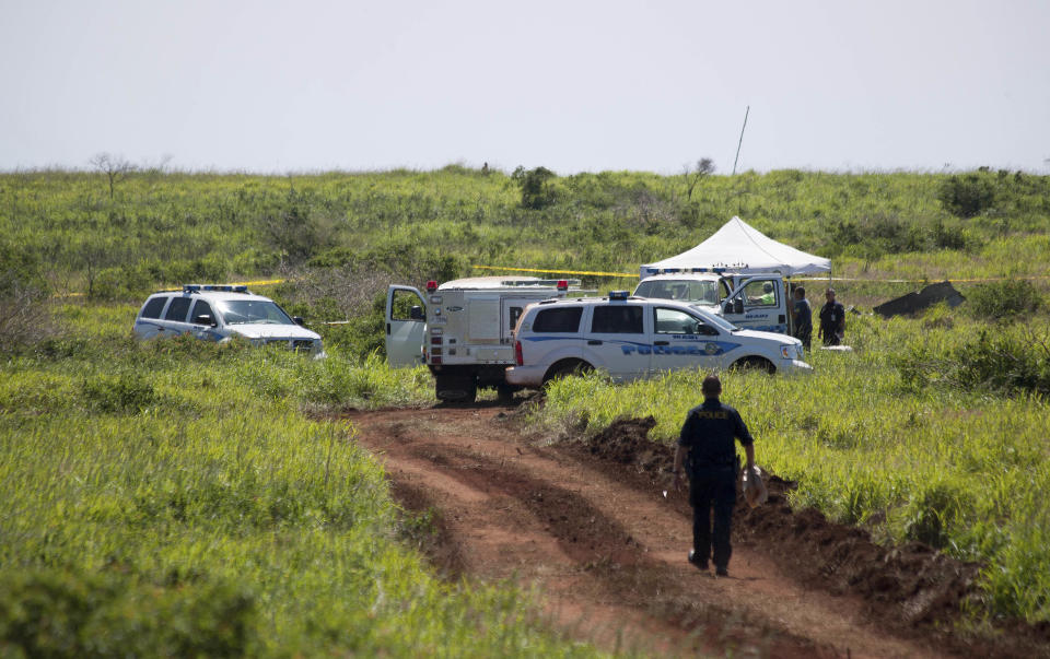 This Thursday, Feb. 27, 2014 photo released by Russell deJetley shows officials at the site of a plane crash in Lanai City, Hawaii. A small plane crashed and burst into flames shortly after takeoff from Hawaii's Lanai island, killing three people and leaving three others injured, authorities said Thursday. The crash occurred around 9:30 p.m. Wednesday about a mile from Lanai Airport in the Miki Basin area, Maui County spokesman Rod Antone told The Associated Press. (AP Photo/Russell deJetley)