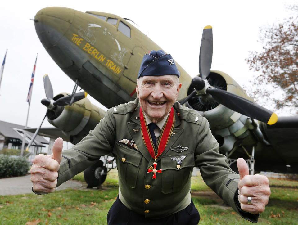 FILE - "Candy Bomber" pilot Gail Halvorsen gives thumbs up in front of an old US military aircraft with the name "The Berlin Train" in Frankfurt, Germany, on Nov. 21, 2016. The man known as the "Candy Bomber" for his airdrops of sweets during the Berlin Airlift when World War II ended nearly 75 years ago has died. Gail Halvorsen was 101 when he died Wednesday, Feb. 16, 2022, in his home state of Utah surrounded by most of his children after a brief illness, James Stewart, the director of the Gail Halvorsen Aviation Education Foundation, said Thursday. (AP Photo/Michael Probst, File)