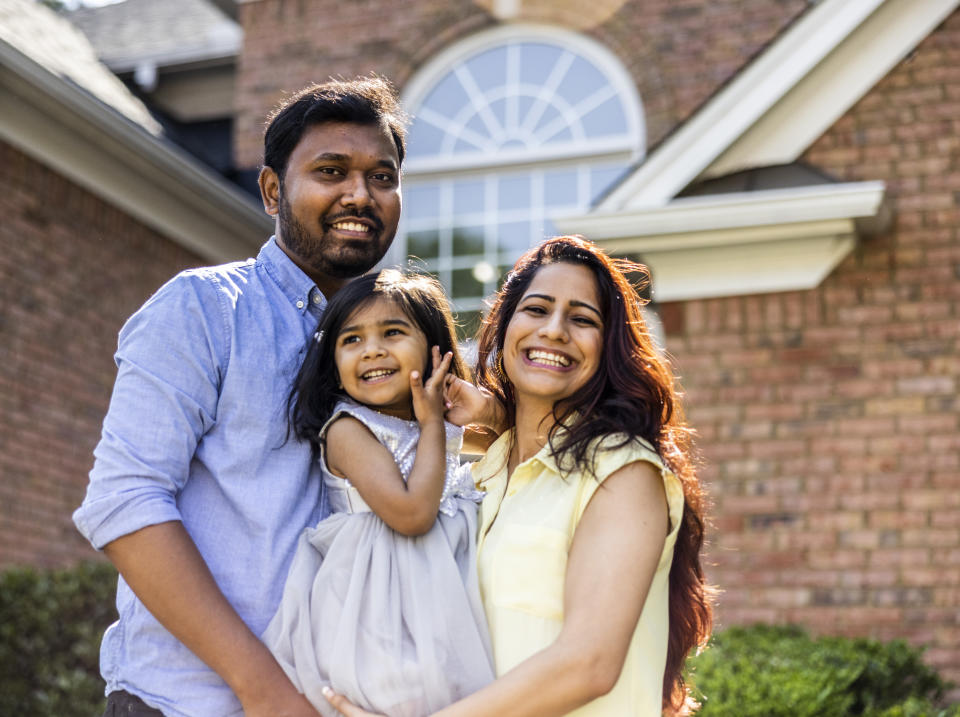 Portrait of young family in front of home