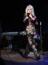 <p>Here, at a 2011 event with country singer-songwriter Marty Stuart, Dolly reimagines what the pantsuit can be with colorful beading in a botanical motif.</p>