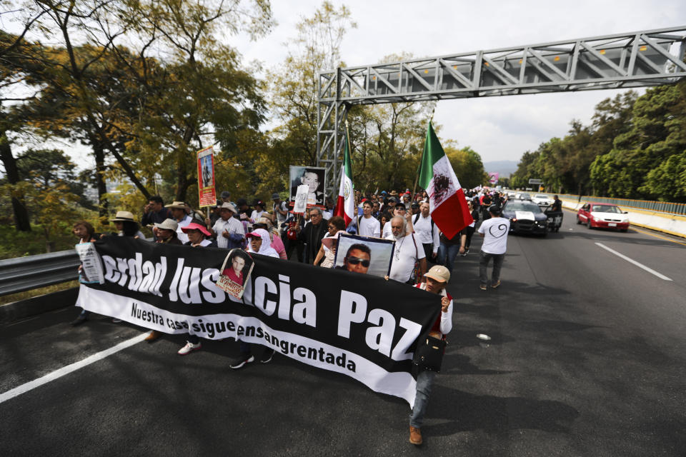 People attend a protest against violence called "Walk for Peace" as they leave Cuernavaca, Mexico, Thursday, Jan. 23, 2020, with Mexico City as their destination. Activist and poet Javier Sicilia is leading his second march against violence in Mexico, this time accompanied by members of the LeBaron family, and plan to reach Mexico's National Palace on Sunday. (AP Photo/Eduardo Verdugo)