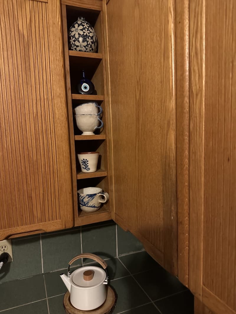 Wooden cabinets with coffee mugs of different styles.